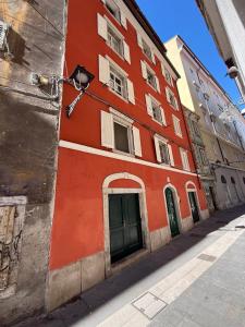 a red building on the side of a street at James Joyce - Metro Cubo in Trieste