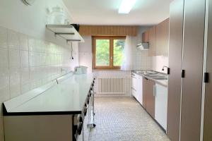 a kitchen with white counter tops and a window at Christiania 431 in Bagnes