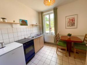 a kitchen with a table and a sink and a stove at Hotel Gutshaus Kajahn in Gustow