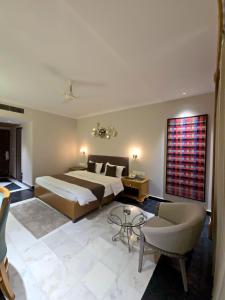 a bedroom with a large bed and a table at Hotel Supreme Suites I B2B Friendly I Ludhiana in Ludhiana +23 photos