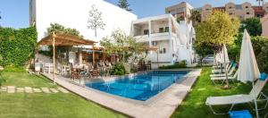 una piscina con sedie e ombrelloni accanto a un edificio di Tree of Life Art Hotel ad Agia Marina Nea Kydonias