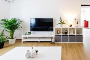 a living room with a television on a white entertainment center at Holiday House Rafo in Šamorín