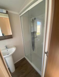 a bathroom with a glass shower and a sink at Caravan Church farm holiday village in Pagham
