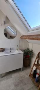 a bathroom with a white sink and a mirror at Chambres d'Hôtes Ferme de la Baie in Roz-sur-Couesnon