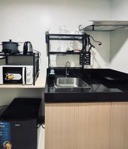 eine Küche mit Spüle und Mikrowelle in der Unterkunft Snug Retreat with Cozy Vibes in Iloilo City + 4 Fotos