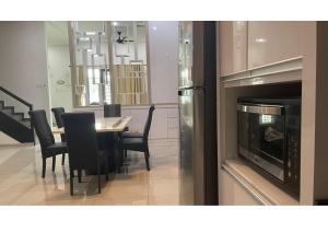 a dining room with a table and chairs and a microwave at Restful Homestay in Bukit Mertajam