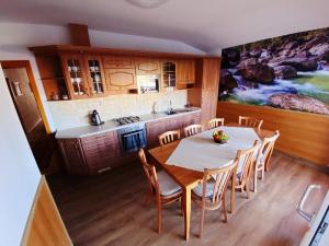 a kitchen with a table and chairs and a kitchen with a painting at Apartmány EKOSERVIS SLOVENSKO in Veľký Slavkov