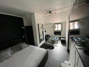 um quarto com uma cama branca e um espelho em Suite Apollon em Saint-Étienne