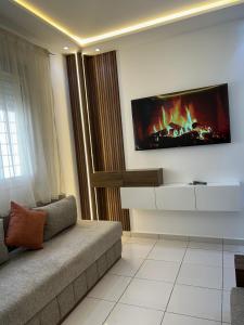 a living room with a couch and a tv on the wall at Sable d'or in Tangier