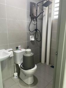 a bathroom with a toilet with a green tank at Prima Resident Meru Ipoh in Ipoh