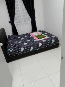 a bed with a black and white comforter on the floor at Prima Resident Meru Ipoh in Ipoh +3 photos