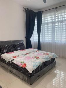 a bed with a quilt on it in a bedroom at Prima Resident Meru Ipoh in Ipoh