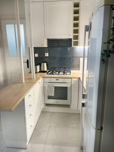 Una cocina blanca con estufa y refrigerador. en Podmiejska 16, en Łódź