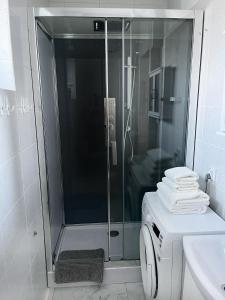 y baño con ducha y lavadora. en Podmiejska 16, en Łódź