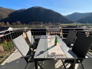 a table and chairs on a balcony with a bottle of wine at Ferienwohnung Moseltraum, bis zu 6 Pers, mit 3 Schlafzimmer und Panoramabalkon in Müden