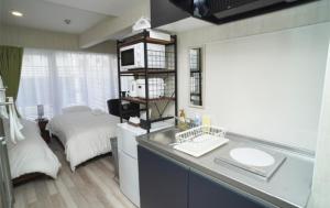 a bathroom with a sink and a bed in a room at New Normal Condo in KENCHOMINAMIGUCHI ニューノーマルコンドイン県庁南口 in Naha +22 photos