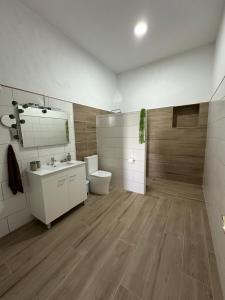 a bathroom with a toilet and a sink and a mirror at Fuerte Roche 2 in Tuineje +10 photos
