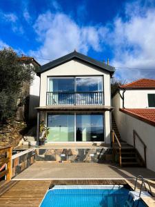 a house with a balcony and a swimming pool at Casinha in Celorico de Basto