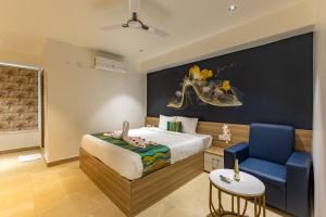 a bedroom with a bed and a blue chair at Hiwa Boutique Hotel in Hyderabad +25 photos