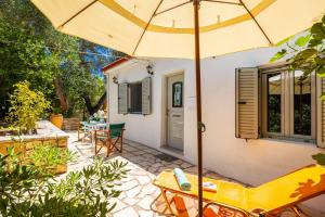 a patio with an umbrella and chairs and a table at Stefanos Cottage in Longós +6 photos