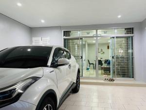 a white car parked in front of a house at Tiwa Homestay Ban Phru in Hat Yai