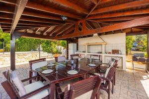 a wooden table and chairs on a patio at Villa Irene Palace in Paphos