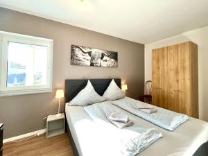 a bedroom with a large white bed and a window at Ferienwohnung Moseltraum, bis zu 6 Pers, mit 3 Schlafzimmer und Panoramabalkon in Müden