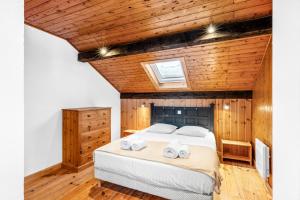 una camera da letto con un letto grande con due asciugamani di Chalet white Horizon lodge a Les Gets