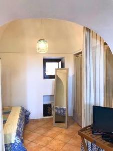 a bedroom with a bed and a mirror and a table at Residence Dammusi Riah in Pantelleria
