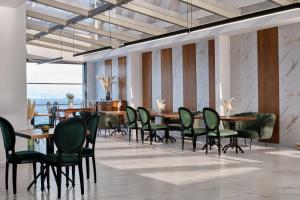 a dining room with tables and chairs and a room with the ocean at Mythical Coast Wellness Retreat in Mytilene