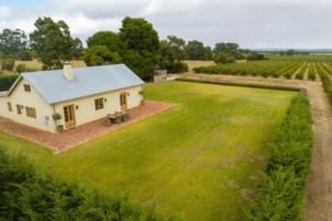 a small white house in a field of grass at Ciel House - French style in Angaston