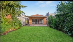 Una casa con un césped verde delante de ella. en south Brighon 4 mins to beach near cafe shops, en Brighton
