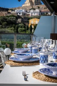 una mesa con platos azules y blancos y copas de vino en Eolian Penthouse, en Milazzo