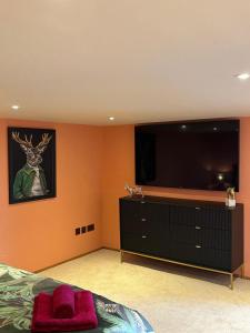 ein Schlafzimmer mit einem großen Flachbildfernseher an der Wand in der Unterkunft Isla's Den in Redhill + 20 Fotos