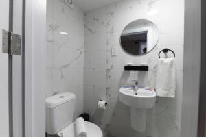 Un baño blanco con inodoro y lavabo. en MARINA HOTEL London, en Londres 23 fotos más