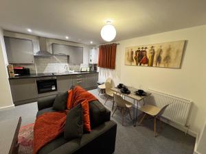 a living room with a couch and a kitchen at town centre 3, 1st floor, king bed entire flat in Huntingdon