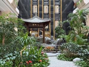 un giardino di fronte a un edificio con pagoda di Beijing Jingyi Hotel a Pechino