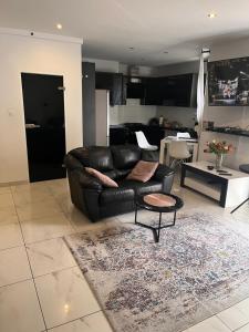 a living room with a leather couch and a table at Green View Kotlarska in Wrocław