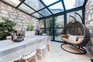 a conservatory with a table and chairs and a swing at Atrium Town House in Rovinj