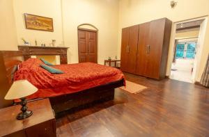a bedroom with a bed with a red comforter at Shanthiniketan Heritage in Coonoor +2 photos
