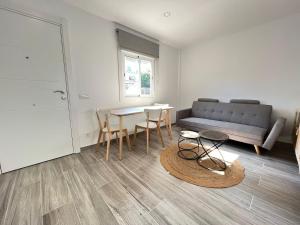 Una sala de estar con un sofá, una mesa y sillas. en Beautiful renovated studio, en Castelldefels