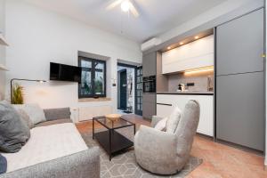 a living room with a couch and chairs and a kitchen at Atrium Town House in Rovinj