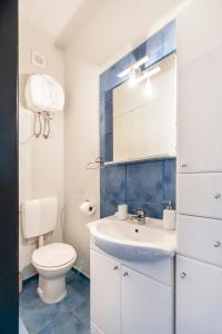 a white bathroom with a toilet and a sink at Atrium Town House in Rovinj +15 photos
