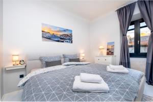 a bedroom with a large bed with two towels on it at Atrium Town House in Rovinj