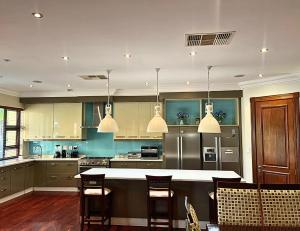 a kitchen with a large island with chairs in it at The Sanctum in Hartbeespoort