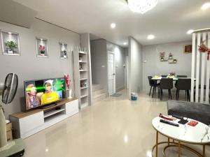 a living room with a television and a dining room at Tiwa Homestay Ban Phru in Hat Yai