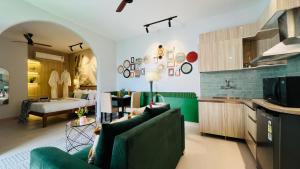 a living room with two green couches and a kitchen at BluO Penthouse #staycation Bathtub, Terrace Garden in Gurgaon