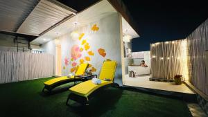 a room with two yellow chairs and a bathroom at BluO Penthouse #staycation Bathtub, Terrace Garden in Gurgaon
