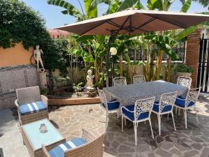 a table and chairs under an umbrella on a patio at Residence Don Turi in Villafranca Tirrena