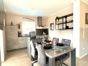 a kitchen with a table and chairs in a kitchen at Ferienwohnung Sonnenterrasse, 1-4 Personen, 2 Schlafzimmer, große Terrasse in Müden +27 photos